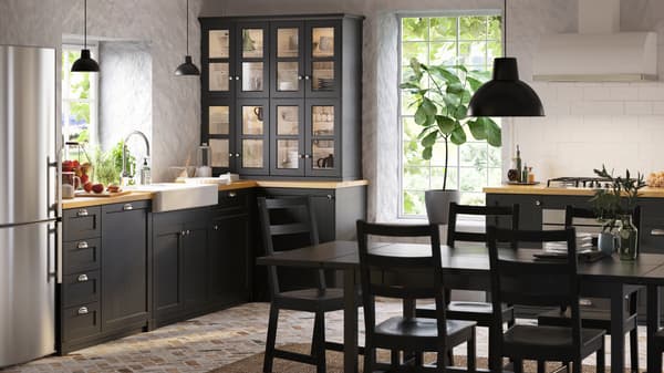 Unha cociña de estilo rústico con frontes de cociña LERHYTTAN en negro, unha mesa extensible NORDVIKEN e cadeiras NORDVIKEN en negro.