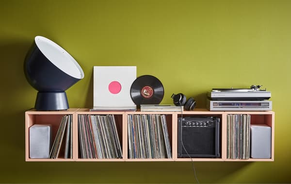 Unha mesa de mesturas caseira emprega armarios EKET laranxa claro para gardar os discos.