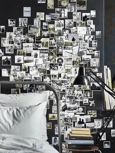 Unha parede do dormitorio cuberta de fotos familiares en branco e negro.