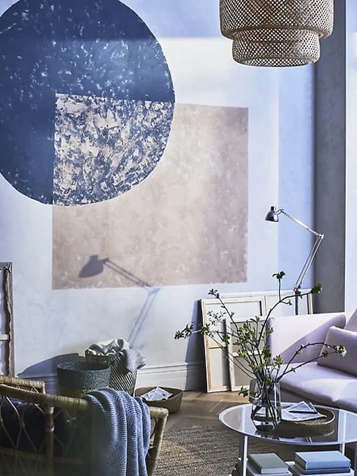 Unha sala de estar con sofá, alfombra, mesa de comedor, cadeiras e caixas de almacenamento contra a parede.