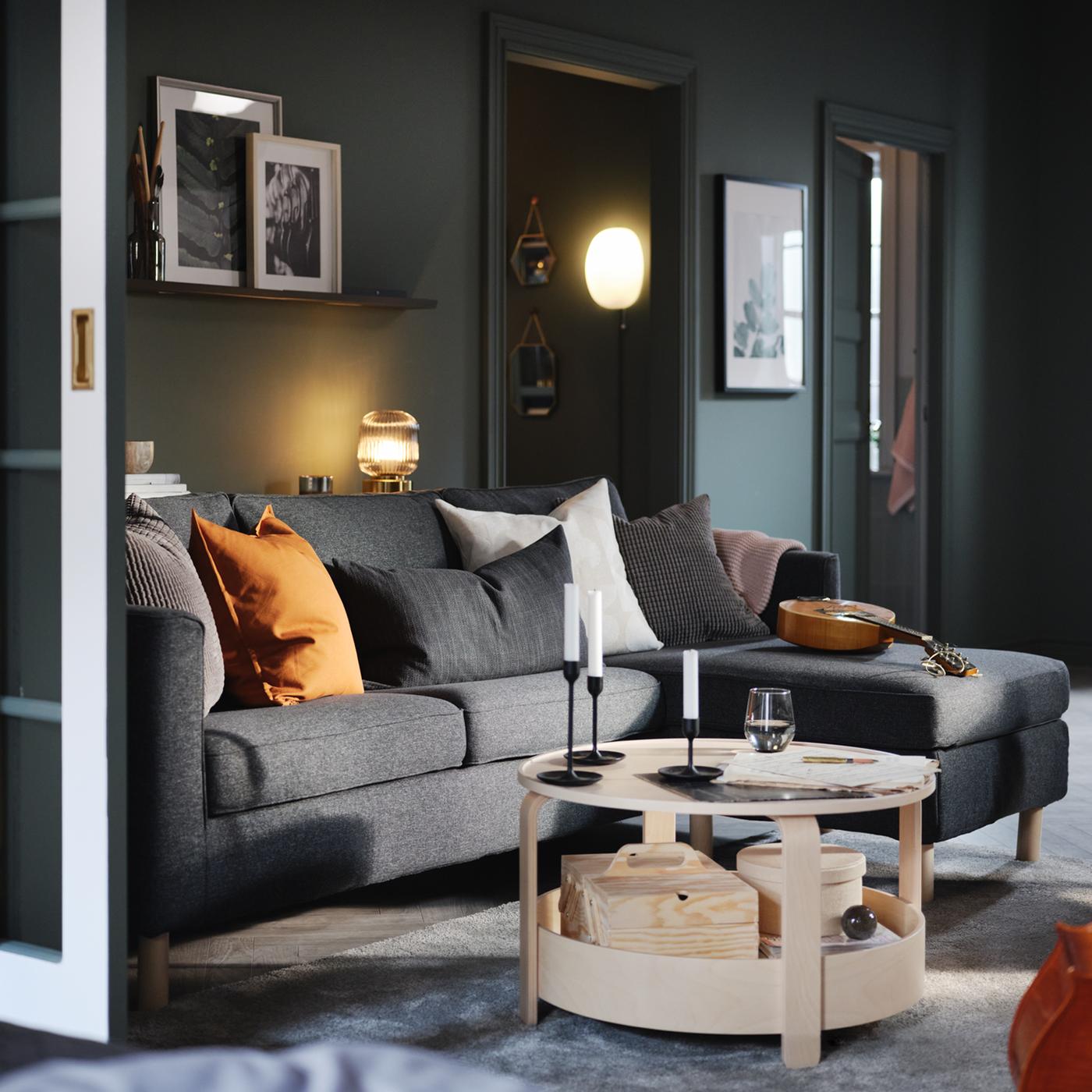 Unha sala de estar cun sofá con chaiselongue e unha mesa de centro.