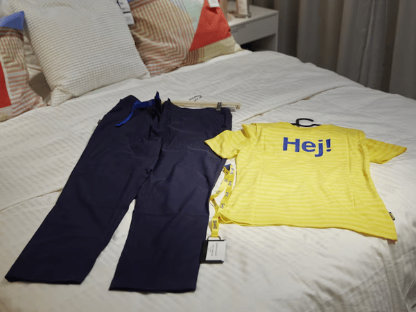 Uniforme d'IKEA groc i blau amb la targeta d'empleat.