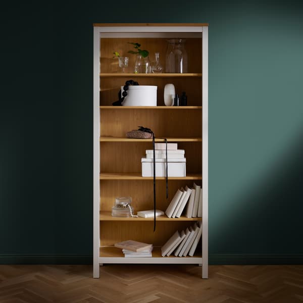 Uno scaffale HEMNES bianco appoggiato ad una parete dipinta di verde