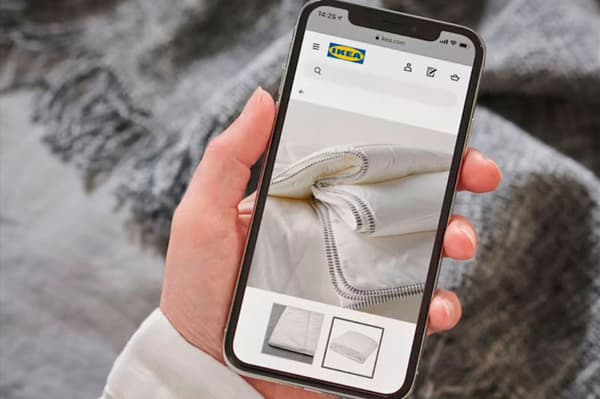 Uno smartphone che mostra l'app IKEA con dettaglio su una coperta.