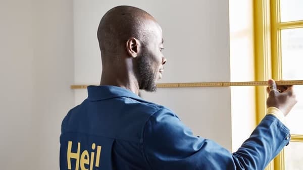 Uomo che sta misurando lo spazio per montare un pensile cucina.