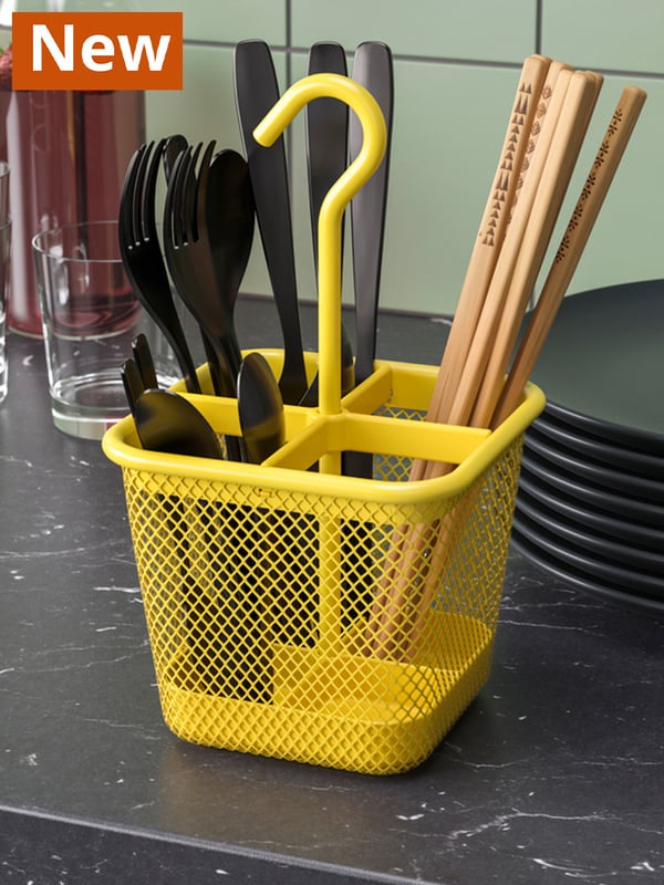 UPPDATERA yellow cutlery caddy filled with chopsticks and forks and spoons.