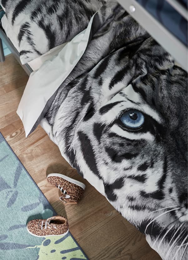 URSKOG grey quilt cover with a printed black and white tiger pattern.