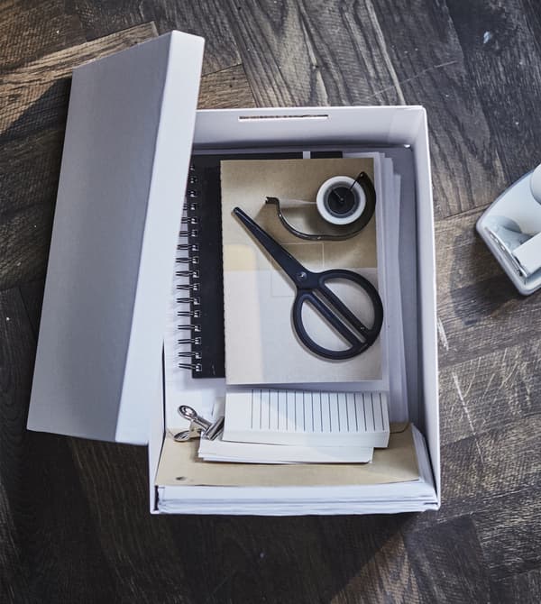 Use a uniform mix of modern home office furniture in your living room work spot. Put office supplies like scissors, tape and papers inside a smart paper box with cut out handles. Try the IKEA TJENA white storage box made from at least 80% recycled paper!