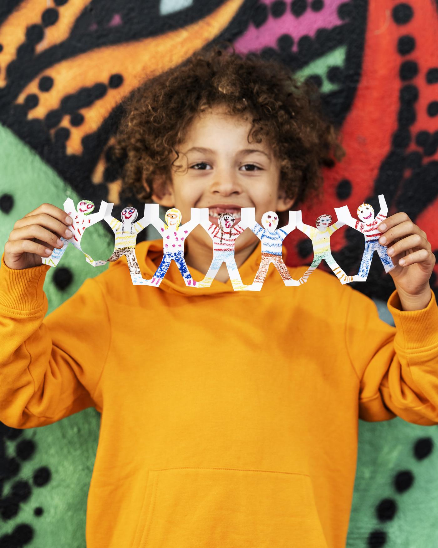 uśmiechnięty chłopiec trzyma wycinankę 