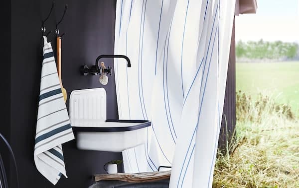 Úspornejšia kúpeľňa s úspornou batériou IKEA a uterákmi a sprchovacou hlavicou OTTSJÖN.