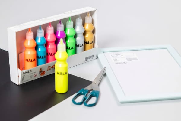Utensilien für personalisierte Notiztafel mit einer Schere Flaschen mit Farben und eine Leinwand.