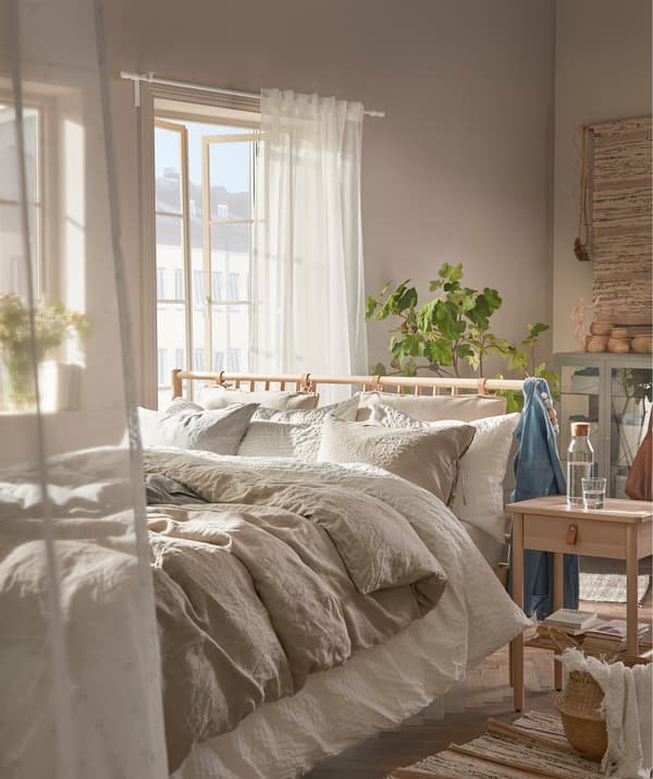 Utilise des voilages légers et une palette de coloris naturels et clairs pour créer une ambiance aérienne et cosy dans la chambre à coucher.