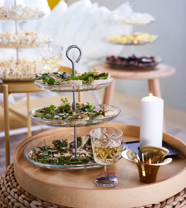 Utilisez des plats à étage pour les snacks et les petits fours, vous gagnerez de la place. Placez-les sur des tables d’appoint et des tabourets partout dans le séjour. Cela donnera l’occasion aux invités de bavarder et de faire connaissance au lieu de rester dans leur coin.