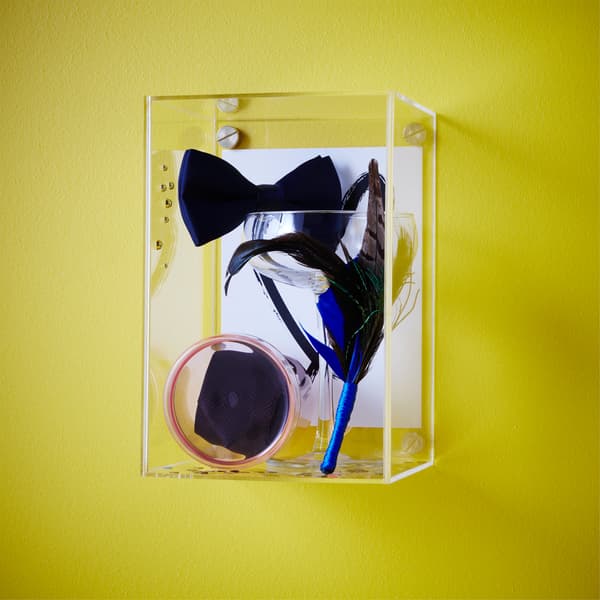 Utilisez la boîte vitrée BJÖRNARP de chez IKEA pour transformer des souvenirs de mariage en accessoires de décoration. Nœud papillon, chaussures, boutonnière... Tout est exposé au regard derrière les parois en acrylique transparent.