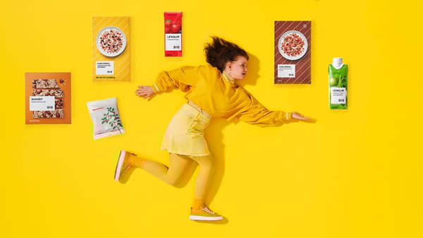 Úvodní foto ke Kvíz plný zdraví, kde dívka ve žlutém běží pod výrobky, které lze koupit ve Švédském obchodě s potravinami 