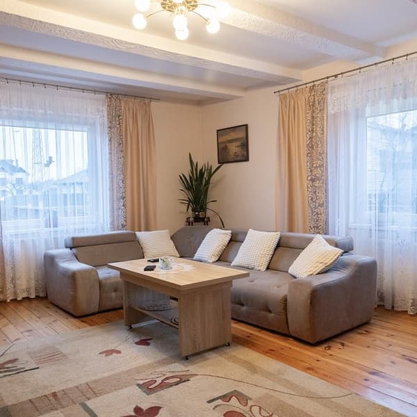 Уютная гостиная с угловым диваном, столиком и большими окнами
