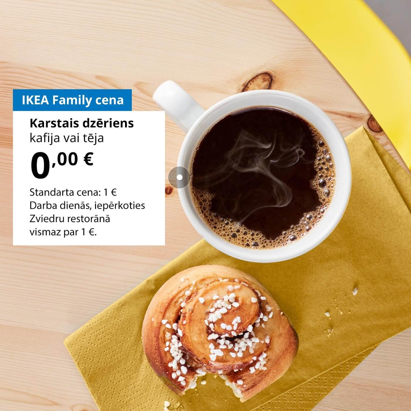 Uz koka galda atrodas iekosta kanēļmaizīte un kafijas krūze. Blakus krūzei uz balta fona redzams piedāvājums IKEA Family kluba biedriem: karstais dzēriens (kafija vai tēja) par 0 €, standarta cena – 1 €.