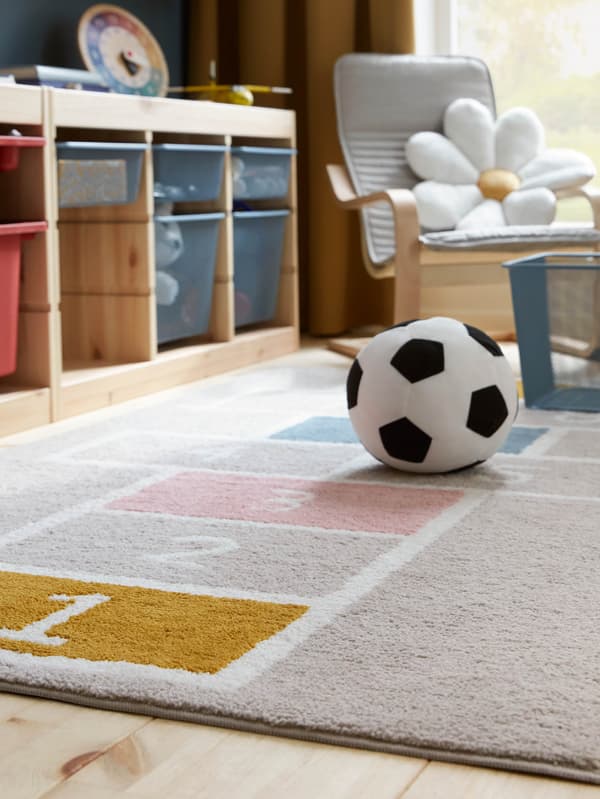 V detskej izbe s úložnými dielmi TROFAST je lopta SPARKA na koberci STÄPPSPARV.