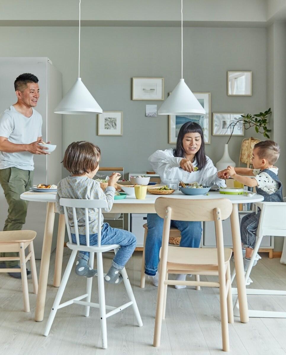 V jedilnici v naravnih tonih sedi družina pri zajtrku.