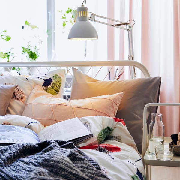 V malej spálni môžete bielu stolovú lampu využiť ako lampu na čítanie na nočnom stolíku.