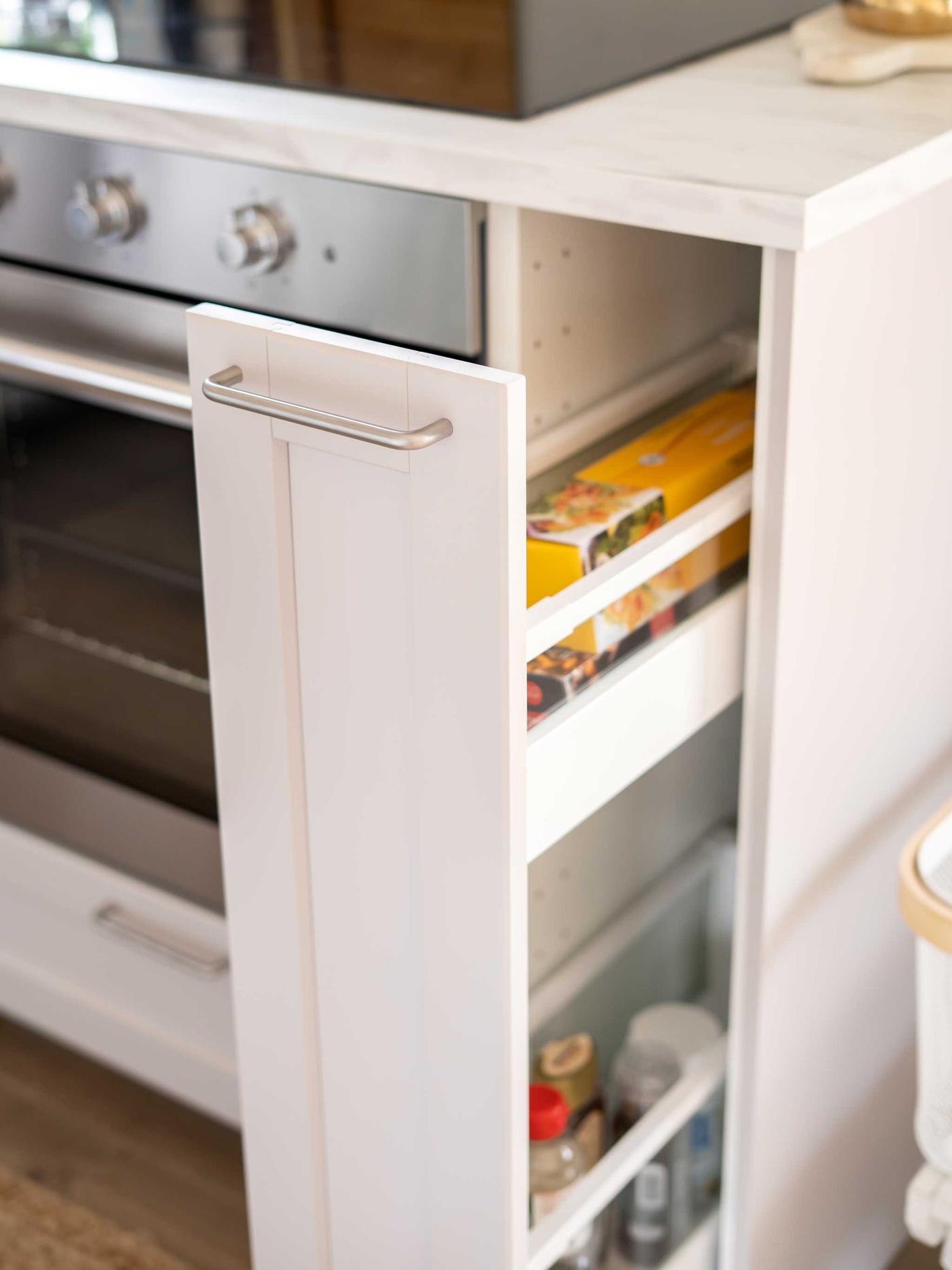 Vaaleanharmaan METOD LERHYTTAN-keittiön avattu pöytäkaappi, jonka sisällä on keittiötarvikkeita.