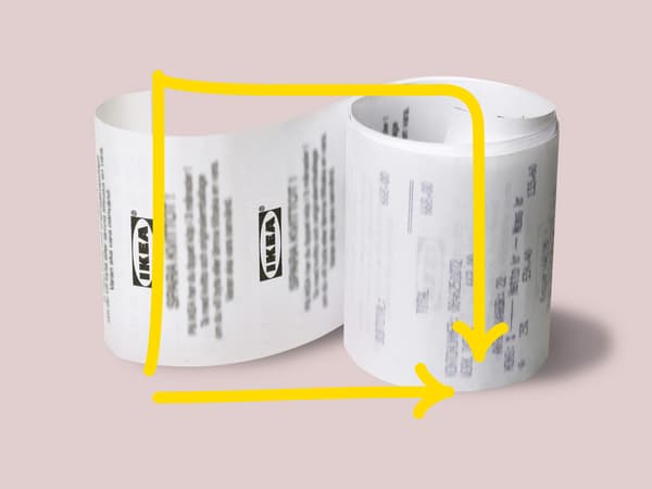 Vaaleanpunaisella pohjalla valkoinen kuitti rullalla sivuttain.