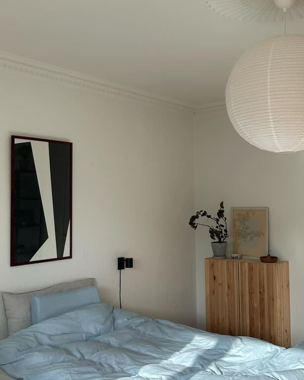 Vaaleassa makuuhuoneessa on musta NYMÅNE-seinävalaisin ja katossa GULLSUDARE-riisipaperivalaisin.