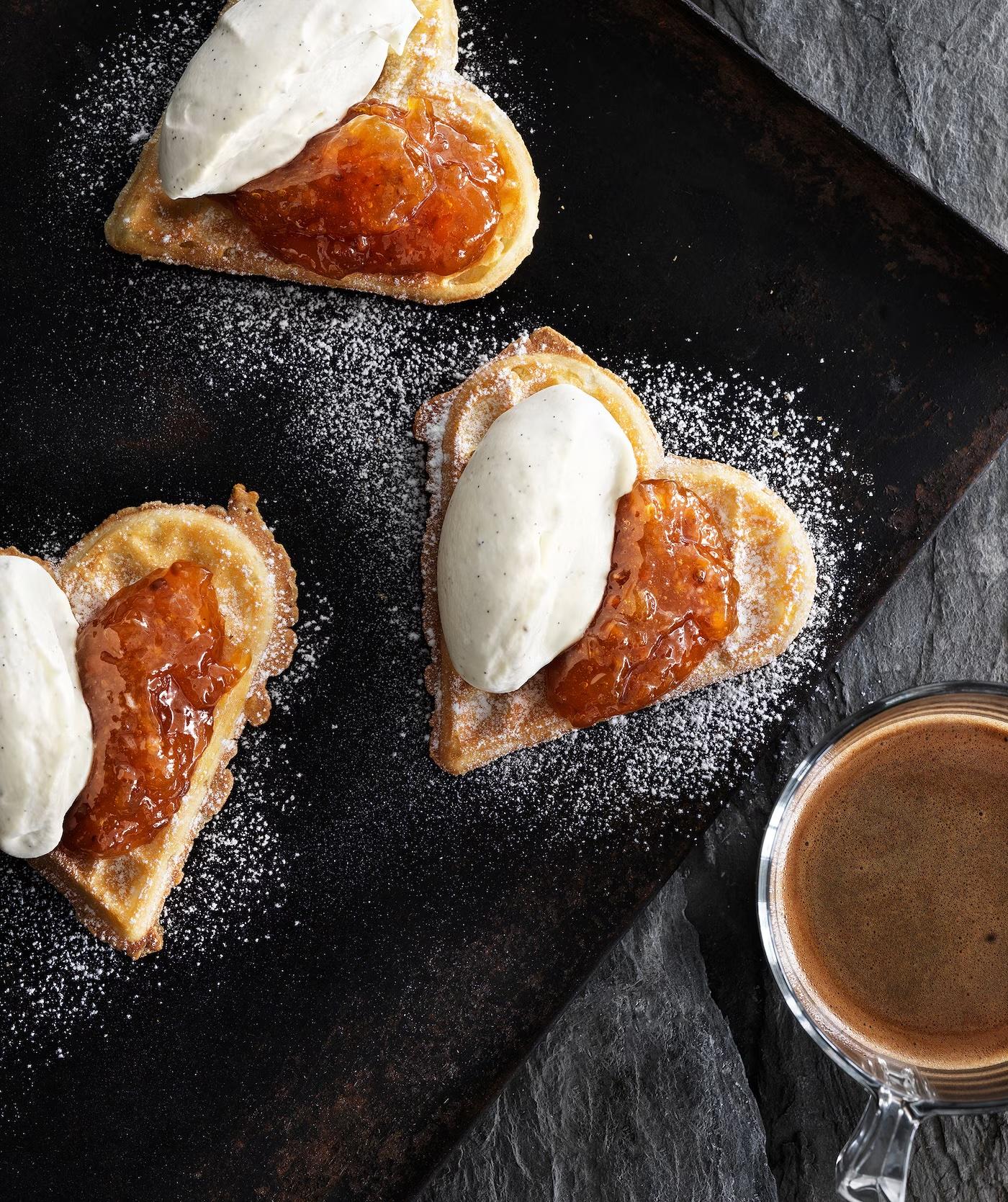 Vaflová srdíčka, jejichž polovičky jsou potřené džemem a krémem.