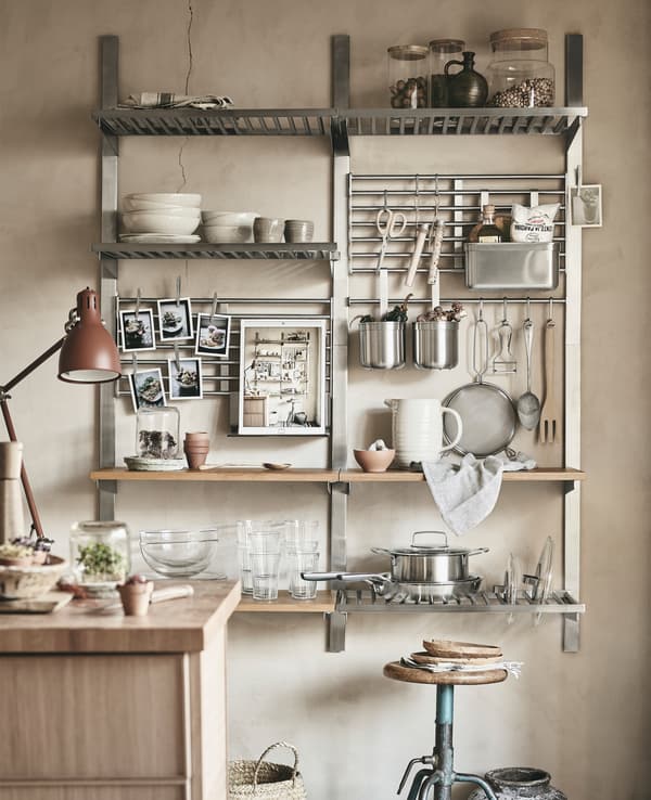 Vaisselle et articles de cuisine rangés sur des tablettes, des barres-supports et des grillages