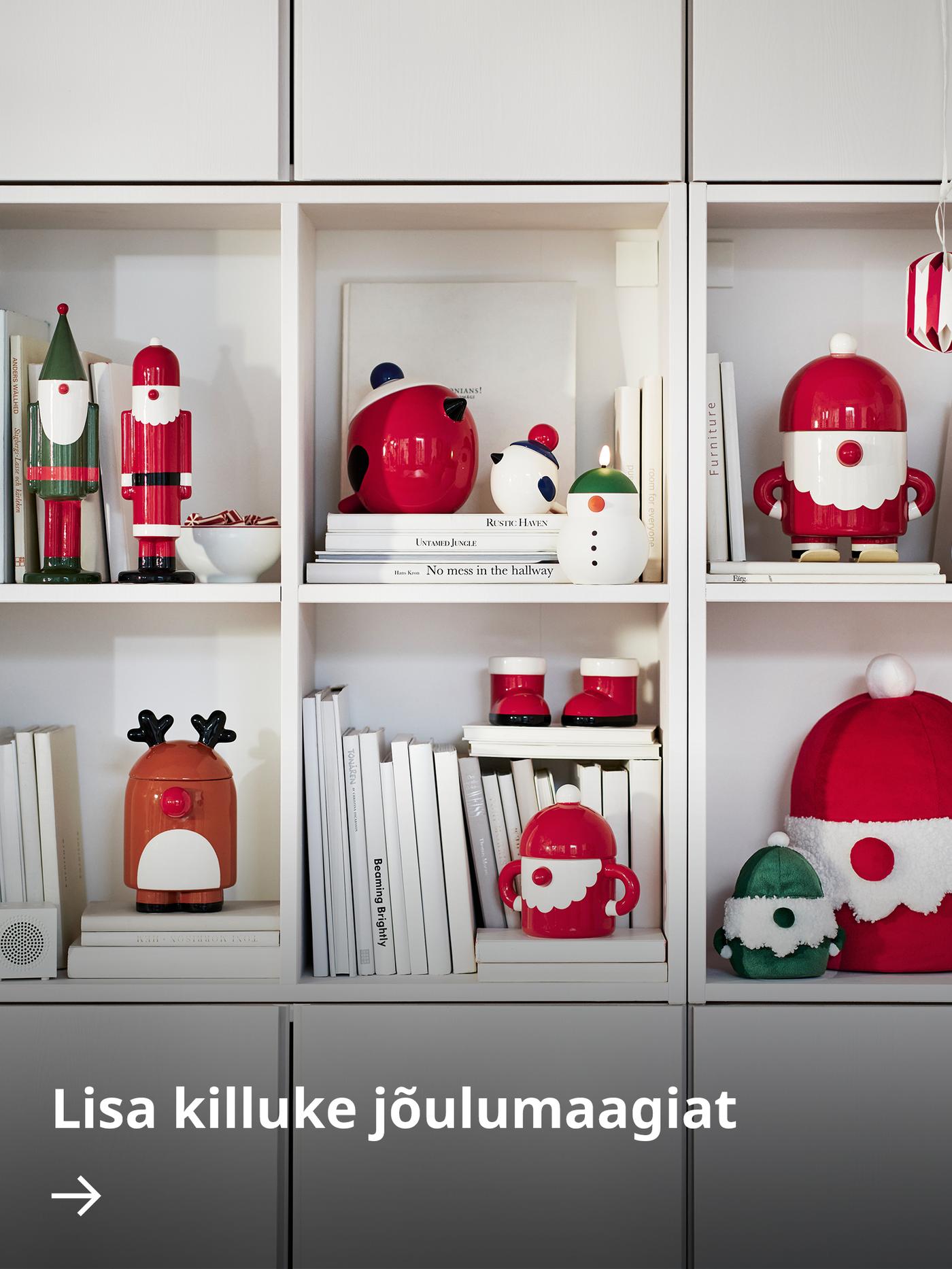 Valge riiul täis pühadehõngulisi VINTERFINT keraamilisi dekoratiivesemeid.
