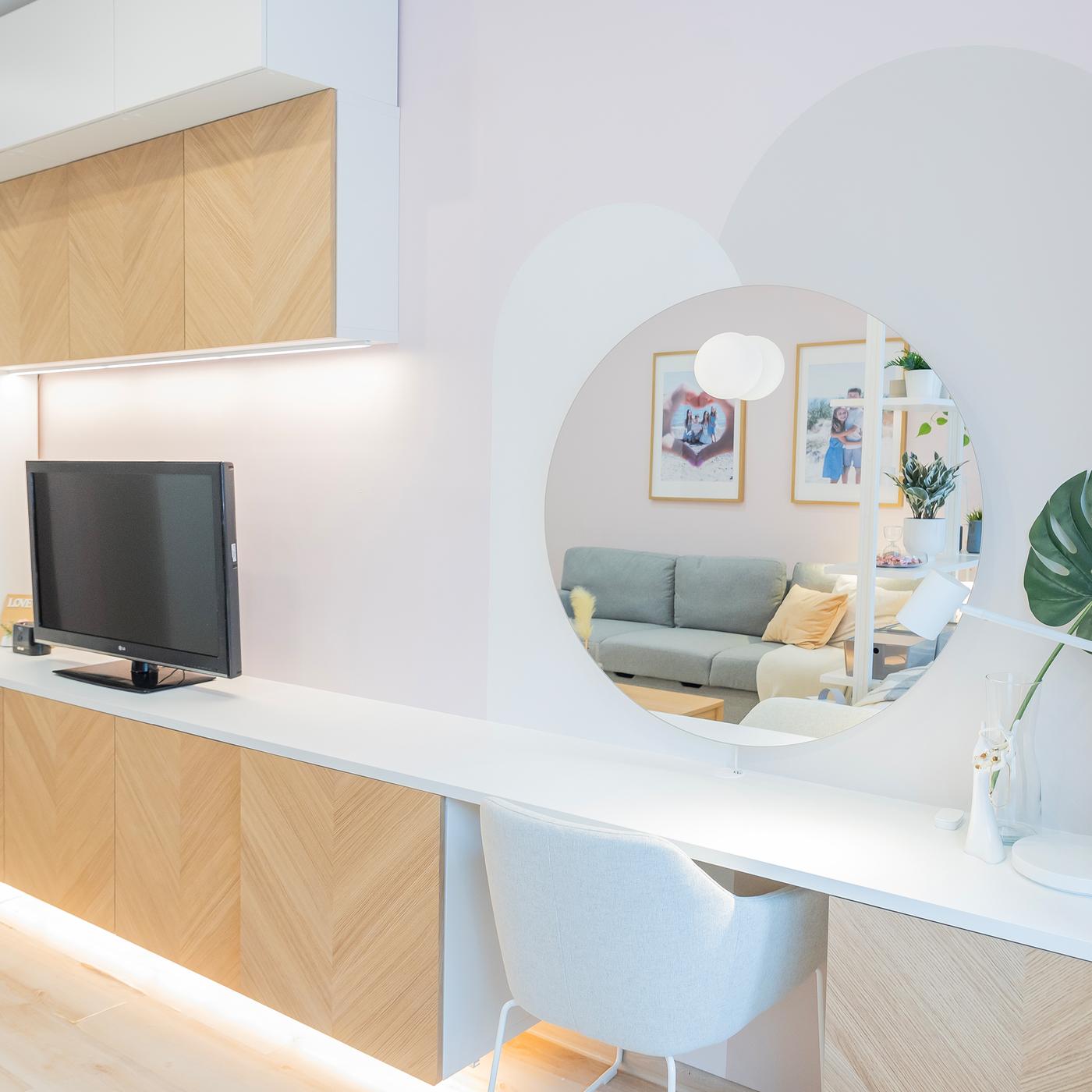 Vanity desk with round mirror and chair in modern interior