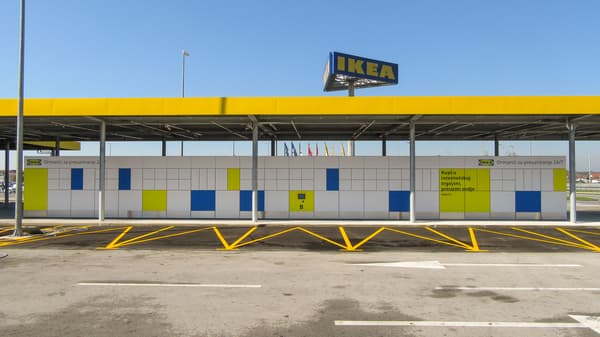 Vanjski ormarići za preuzimanje narudžbi ispred IKEA trgovine, s bijelim, plavim i žutim kvadratima na vratima.
