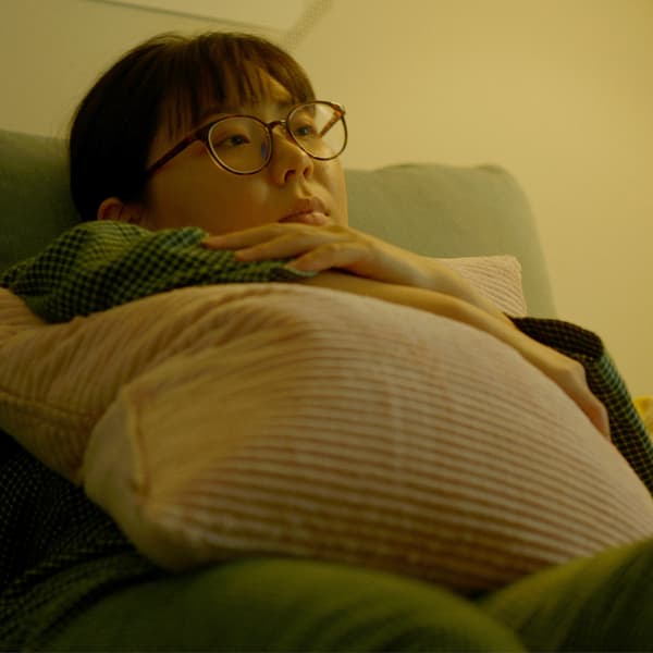붉은 조명을 켠 욕실 샤워기 앞에 서서 VAPPEBY 바페뷔 블루투스 스피커에서 나오는 음악에 맞춰 노래하는 남성.