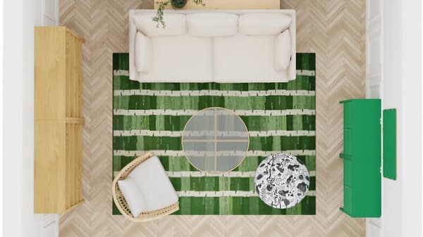 Vardagsrum sett uppifrån med en beige soffa mot väggen, en grönrandig matta i mitten, ett runt glasbord och en fåtölj med vit dyna. Rummet har ljusa trägolv i fiskbensmönster, en grön byrå till höger och en ljus träförvaring till vänster.