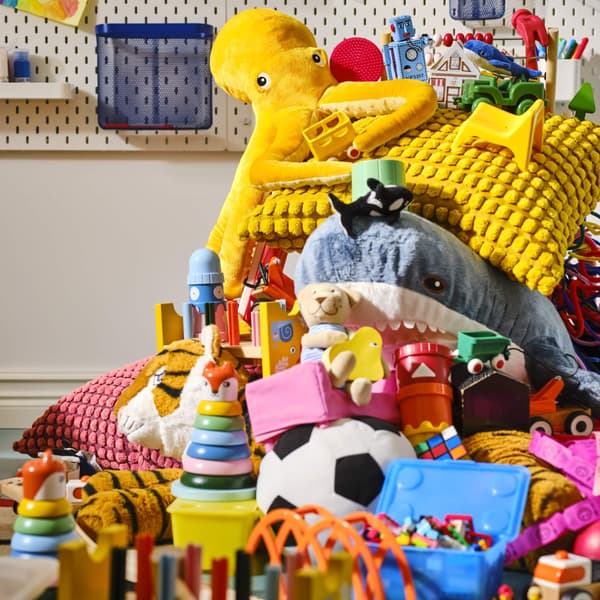 Various colorful soft toys and playing toys stacked in a large pile