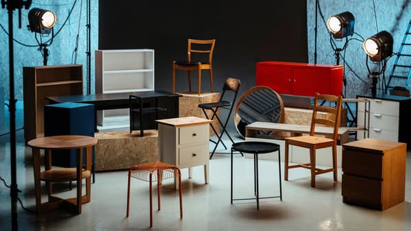 Various pieces of used IKEA furniture from the Zweites Leben store stylishly arranged in a photo studio with spotlights.