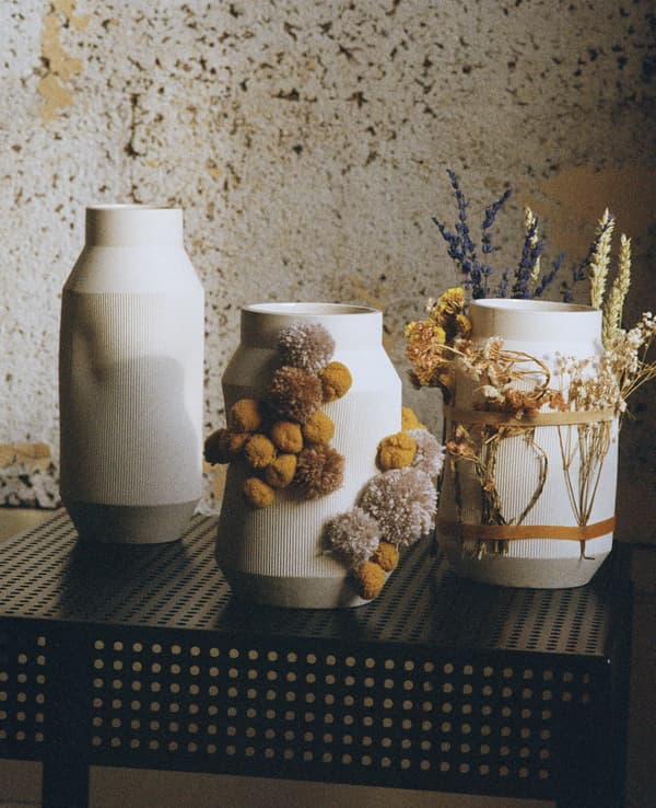 Vases blancs garnis de fleurs séchées.