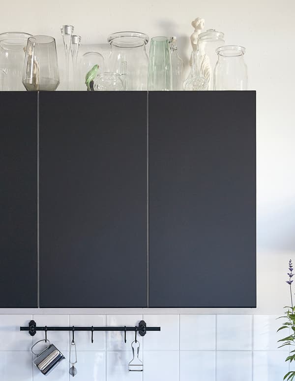 Vasi BERÄKNA in vetro soffiato a bocca, portacandele e brocche in vetro posti su un pensile da cucina color nero.