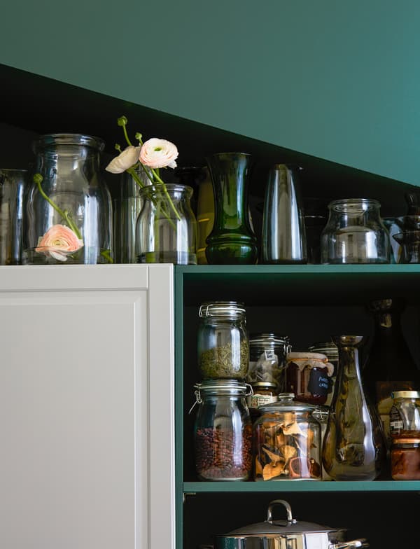 Vasi e barattoli di diverse altezze riposti sotto a un soffitto inclinato - IKEA