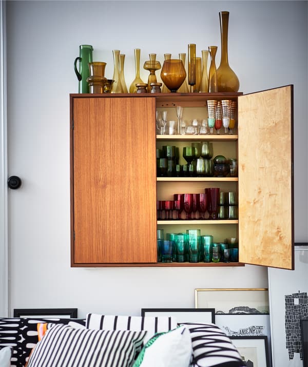 Vasi in vetro sopra e dentro un mobile a parete raggruppati per colore - IKEA Tre prodotti progettati per esporre gli oggetti: