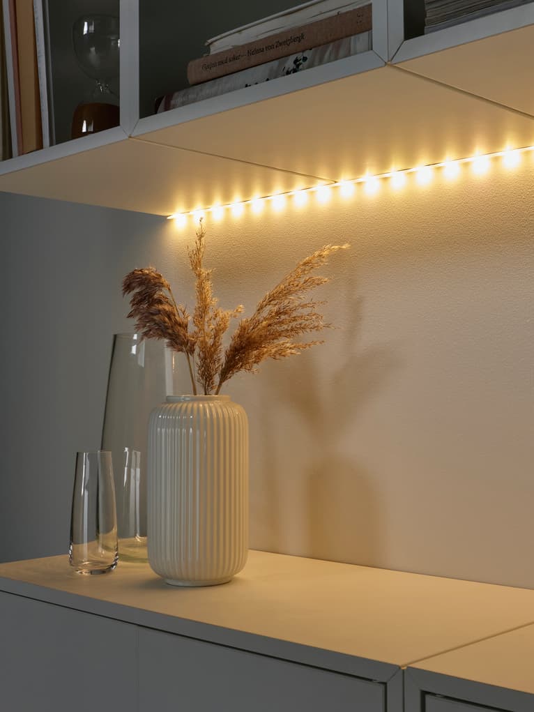 VATTENSTEN cabinet LED strip lighting placed in corner of BESTA shelf and cabinet with white frame. 