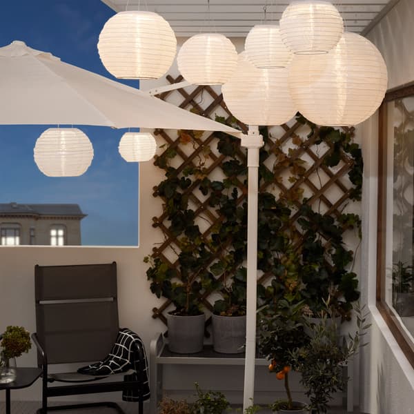Večerní balkon se zavěšenými svítidly SOLVINDEN na stropě.