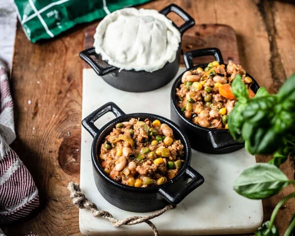 Vegane Hack-Pies werden in kleinen Formen angerichtet und mit Blätterteig bedeckt.