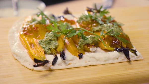 Veggie flatbread met whipped feta, burrata, gecarameliseerde wortelen en pesto van wortelloof