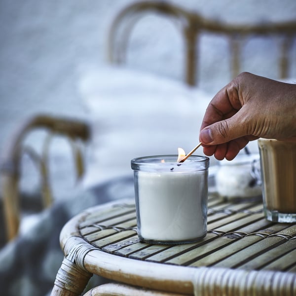 vela blanca encendida con cerilla