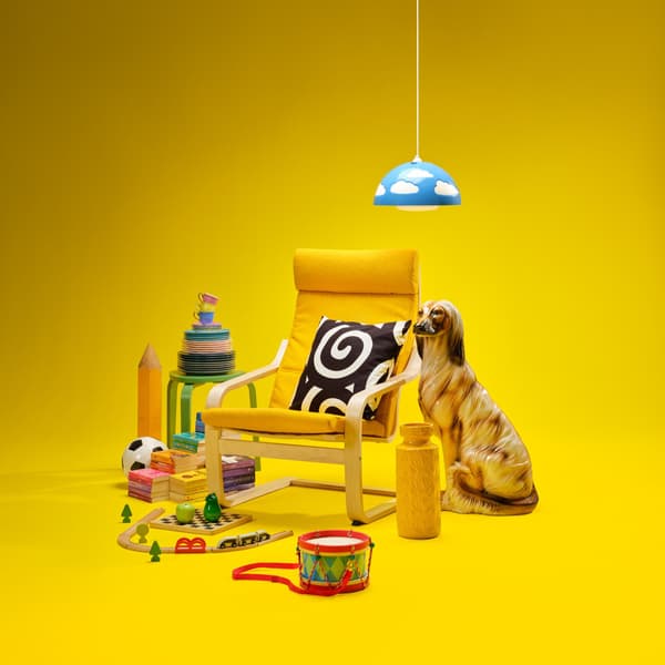 Verschillende IKEA producten, waaronder een gele POANG fauteuille en een KYRRE kruk, staan tegen een gele achtergrond.