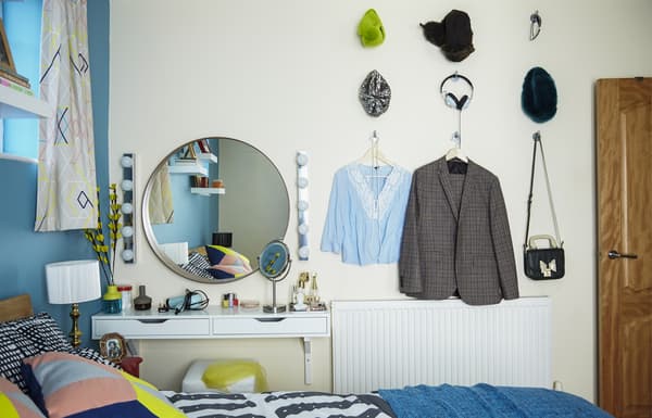 Vêtement et accessoires accrochés au mur de la chambre.