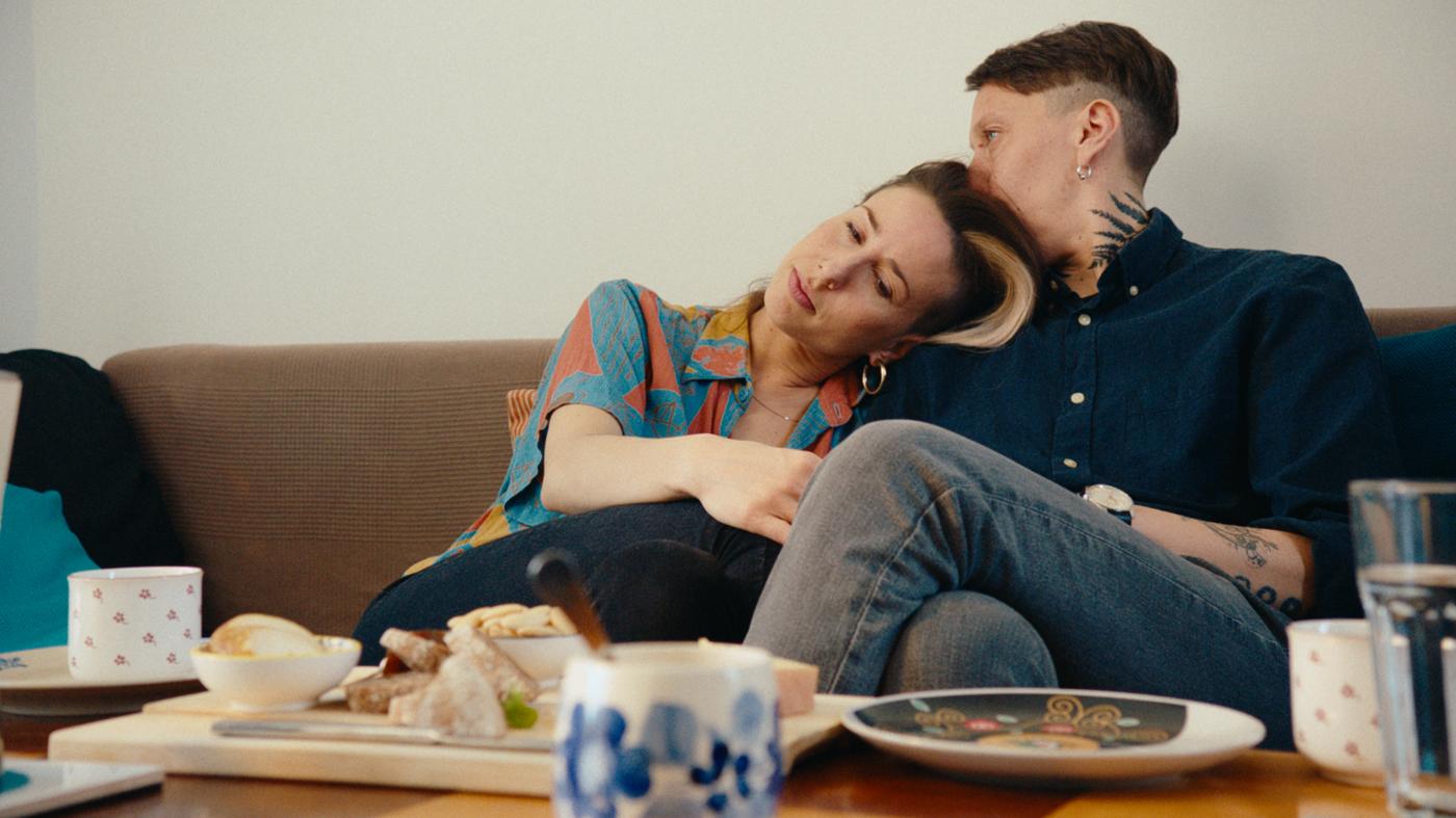 Vêtue d’une tenue multicolore, Clémentine, réfugiée congolaise, se tient debout dans un champ.