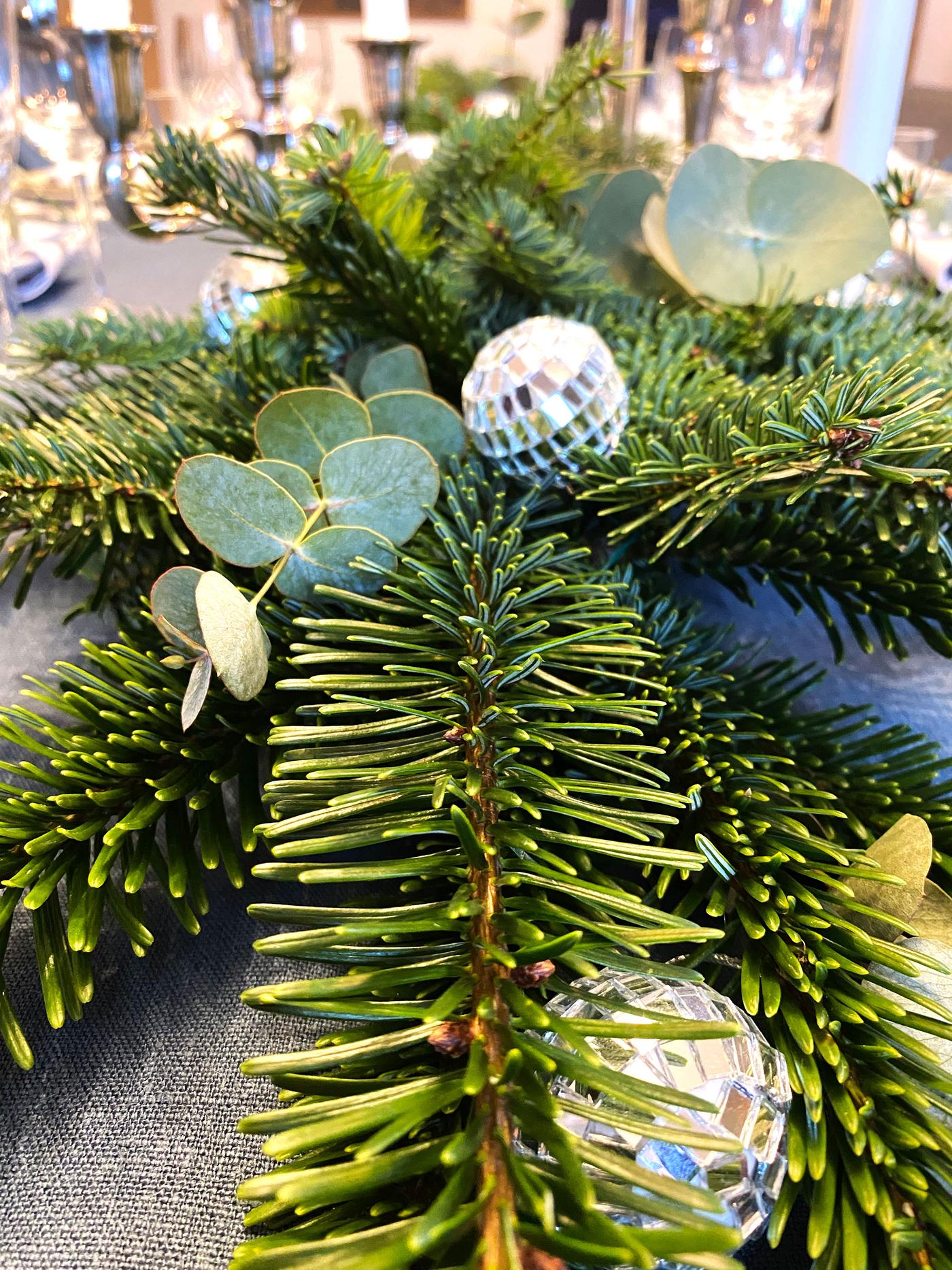 Vi ser et nærbilde av girlandere som ligger på nyttårs-siden med små diskukuler som dekorasjon.