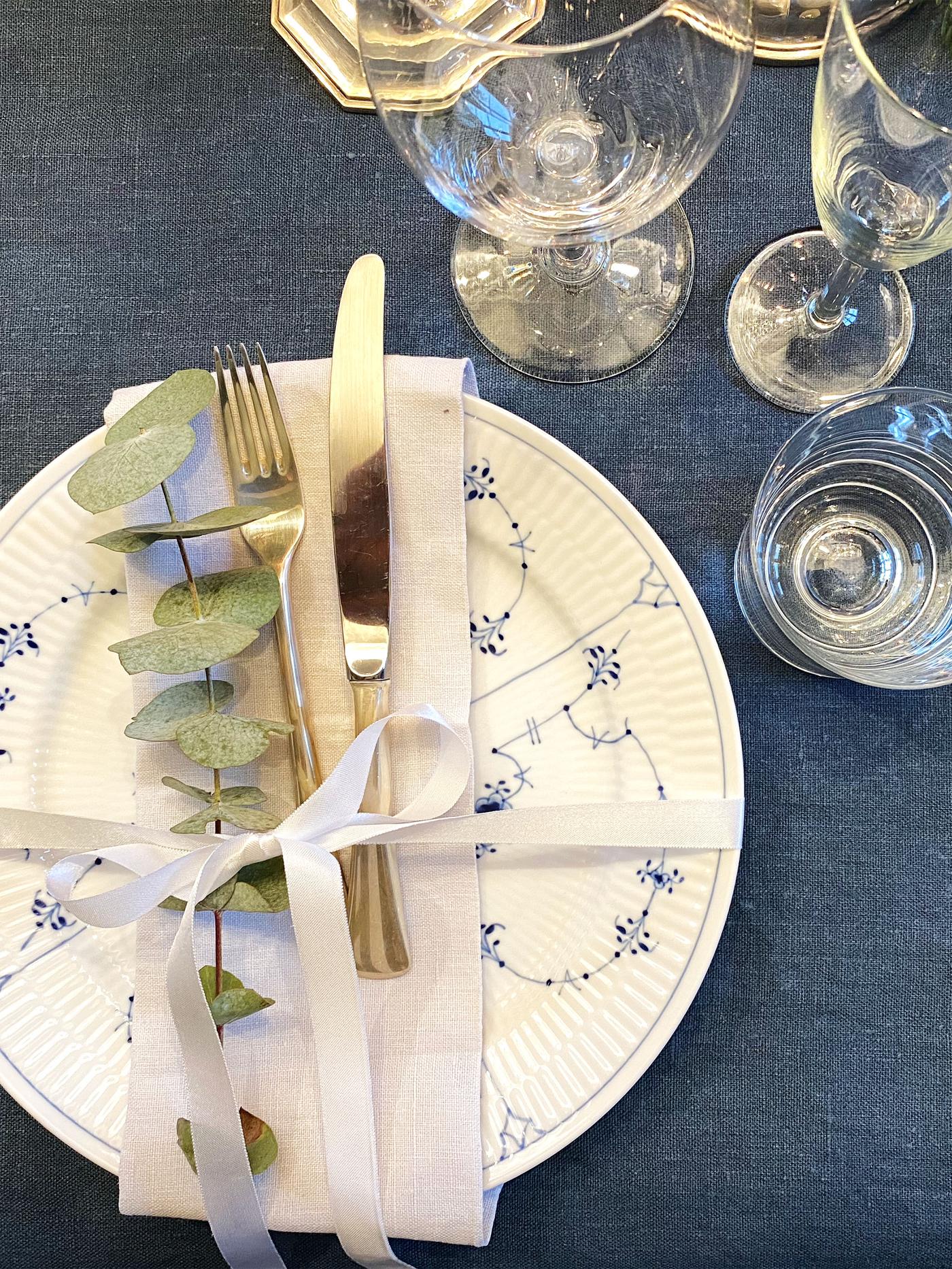 Vi ser tallerken, bestikk og glass på nyttårs-siden